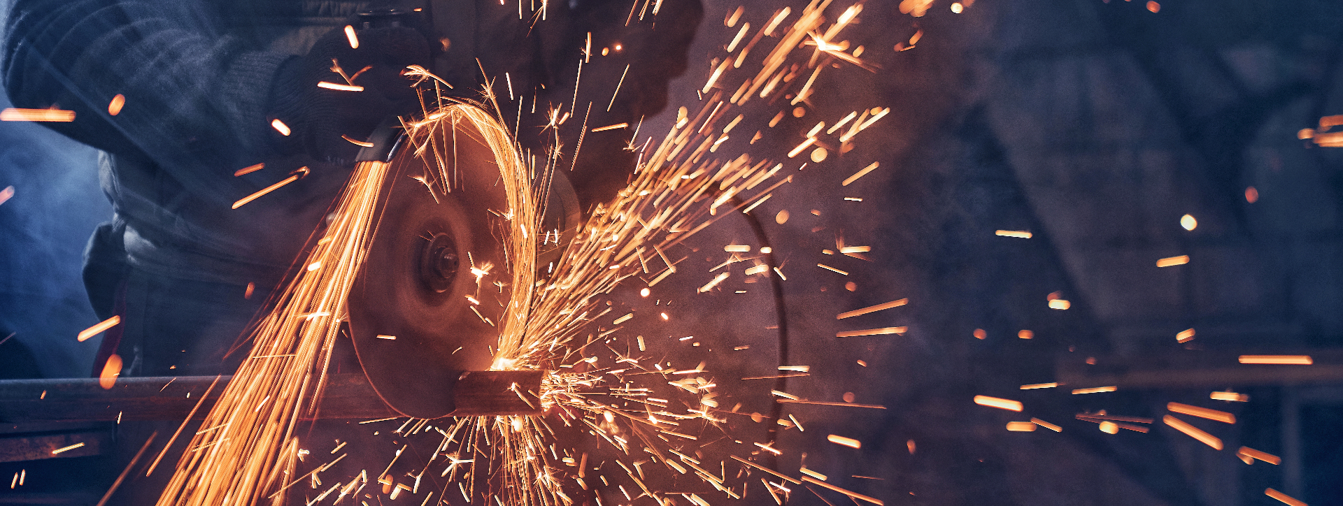 Operário realizando jateamento e polimento de metal industrial